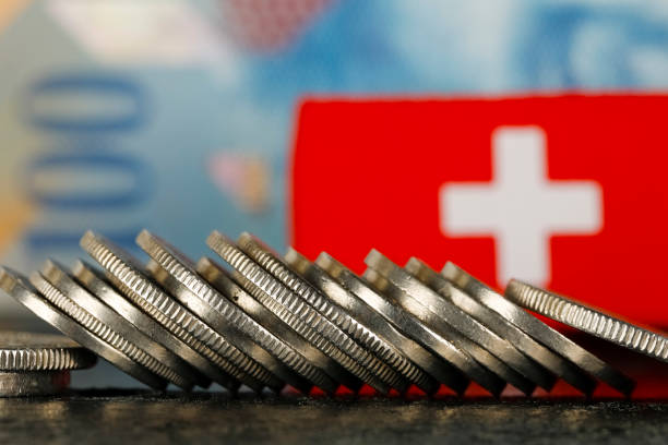 Swiss Money and Flag There are various Swiss coins visible against background of one hundred francs banknote and there is Swiss flag as well swiss culture stock pictures, royalty-free photos & images