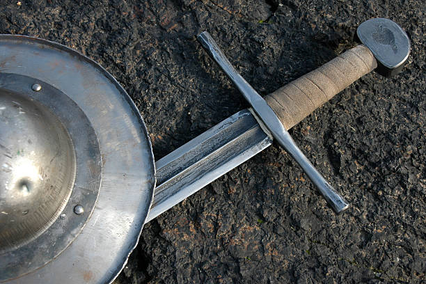 Sword and shield laying on the ground stock photo
