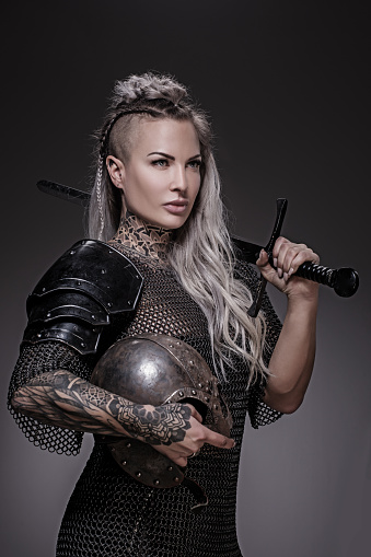 Sword wielding viking warrior blonde female in studio shot