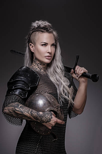Sword wielding viking warrior blonde female in studio shot stock photo