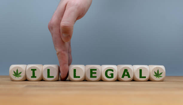 Symbol for Marijuana Legalization. Dice form the word "ILLEGAL" while a hand seperates the letters "IL" in order to change the word to "LEGAL". stock photo
