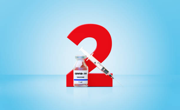 Syringe and COVID-19 Vaccine Bottle Sitting Next To A Huge Red Number Two Over Blue Background Syringe and COVID-19 vaccine bottle sitting next to a huge red number two on blue background, Horizontal composition with copy space. Great use for concepts related to efficacy of COVID-19 vaccines. dose stock pictures, royalty-free photos & images
