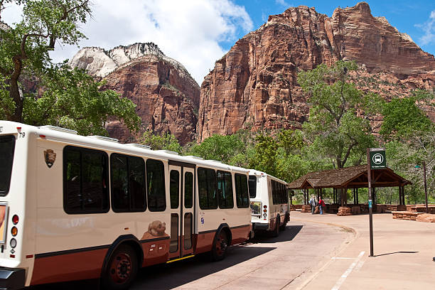 Park Visitors Wait to Board the Shuttle Buses Zion National Park, Utah, USA - May 10, 2011: A system of free shuttle buses helps to limit visitor impact in the national park. jeff goulden environmental conservation stock pictures, royalty-free photos & images
