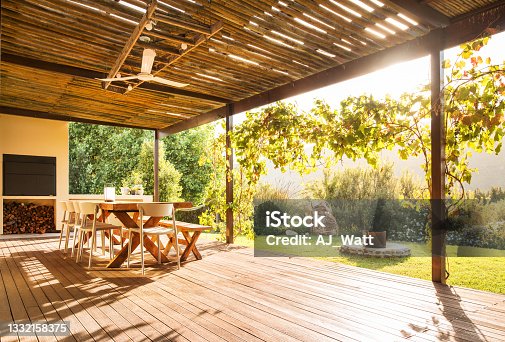 istock Table and chairs on a rustic patio on a sunny afternoon 1332158375