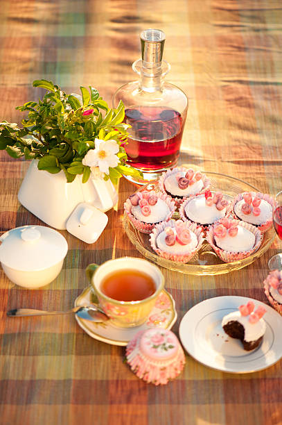 Table in the garden with rose cupcakes. stock photo