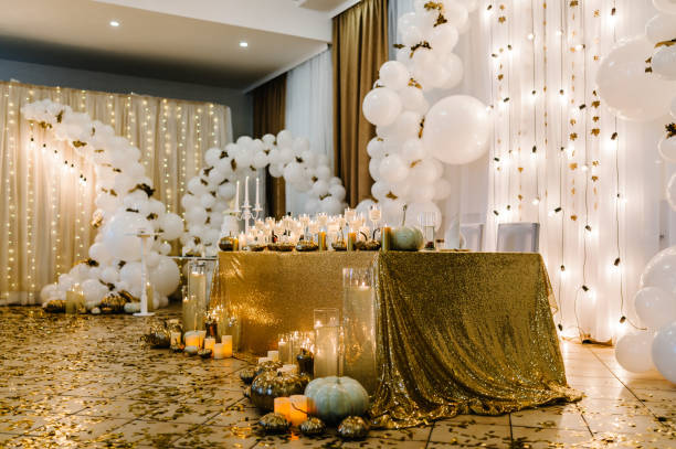 Table setting for wedding. Decorated arch for wedding ceremony. White balloons, candles, autumn leaves and small pumpkins. Autumn location and Halloween decor. stock photo
