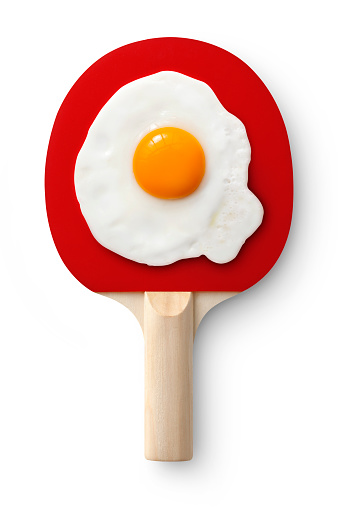 Table tennis racket with fried egg isolated on white background. Photo with clipping path.