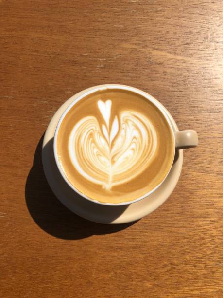A table top photo of a latte taken from directly above with a smartphone camera. stock photo