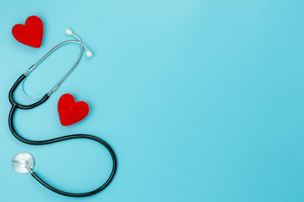 Table top view aerial image of accessories healthcare & medical with Valentines day background concept.telescope with colorful heart shape on blue paper.Flat lay items for doctor using treat patient. stock photo