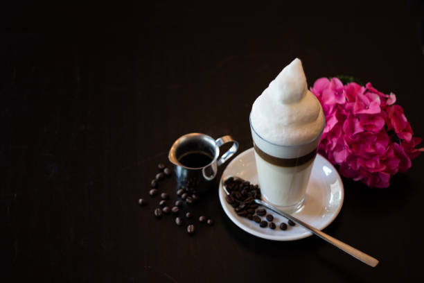 tavolo top-view di latte machiato decorato con chicchi di caffè, pentola per caffè espresso e fiori su tavolo in legno - scholz foto e immagini stock