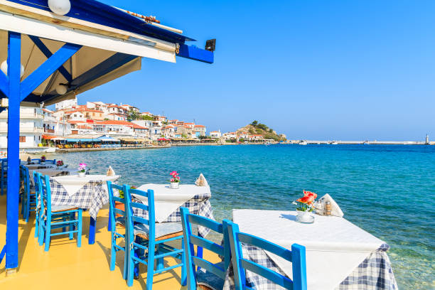 Tables with chairs in traditional Greek tavern in Kokkari town on coast of Samos island, Greece stock photo
