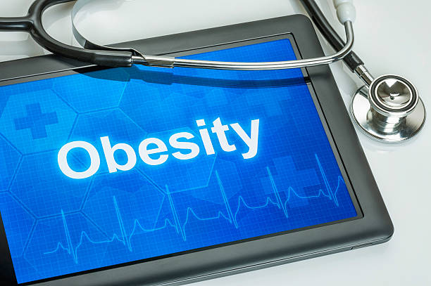 Tablet with the diagnosis obesity on the display Tablet with the diagnosis obesity on the display obesity stock pictures, royalty-free photos & images
