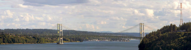 Tacoma Narrows Bridge over strait of Puget Sound connecting Tacoma and Kitsap Peninsula Panoramic view Tacoma Narrows Bridge over strait of Puget Sound connecting Tacoma and Kitsap Peninsula daytime scenic view panorama pierce county washington state stock pictures, royalty-free photos & images