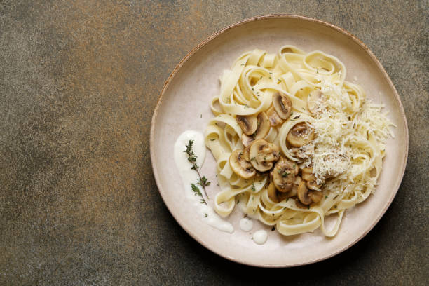 Tagliatelle spaghetti with creamy mushroom pasta sauce Italian pasta in plate tagliatelle stock pictures, royalty-free photos & images