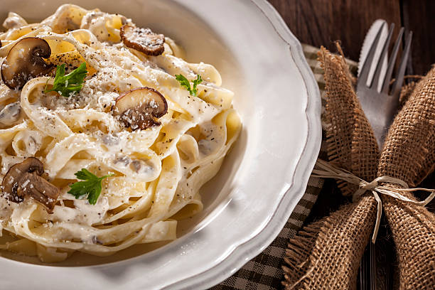Tagliatelle with Mushrooms Tagliatelle with mushrooms, parmesan and fresh parsley tagliatelle stock pictures, royalty-free photos & images