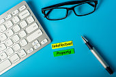 istock INTELLECTUAL PROPERTY - tags on workplace. Theme of protection of intellectual property, inventions, trademark 1205819991
