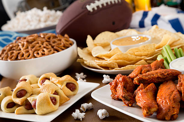 Hot wings, nachos, pigs in a blanket, beer, and popcorn, a tailgate party spread.  Please see my portfolio for other food and drink images.