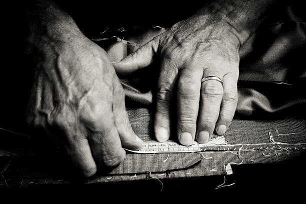 Tailor at work Close up of a older man at work as a tailor. textile industry photos stock pictures, royalty-free photos & images