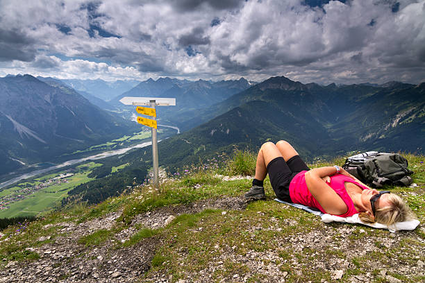 Take a rest on top of mountain a woman is resting on top of mountain after strenuous climb. lechtal alps stock pictures, royalty-free photos & images