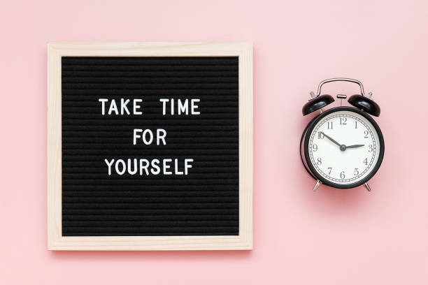 take time for yourself. motivational quote on letterboard and black alarm clock on pink background. top view flat lay copy space concept inspirational quote of the day - lazer imagens e fotografias de stock