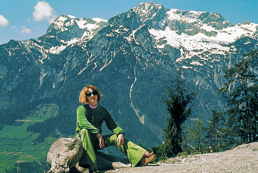 Vintage photo from the seventies featuring a woman Taking a break in the middle of the Alps