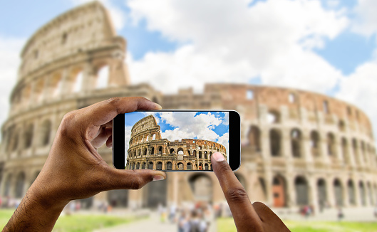 tourist takes a picture with his mobile of coliseum in Rome in Italy