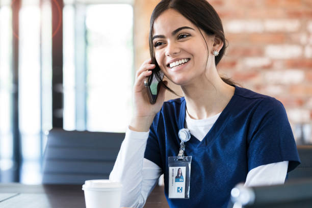 ta paus, sjuksköterska talar på smart telefon - happy scrubs nurse phone bildbanksfoton och bilder
