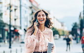 Beautiful young woman talking on the phone on the city street