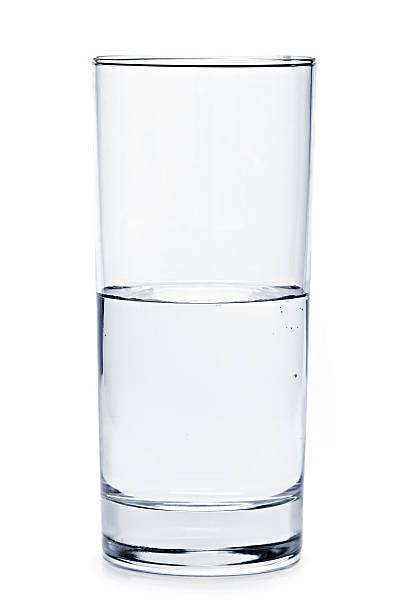 A tall glass half full with pure water stock photo