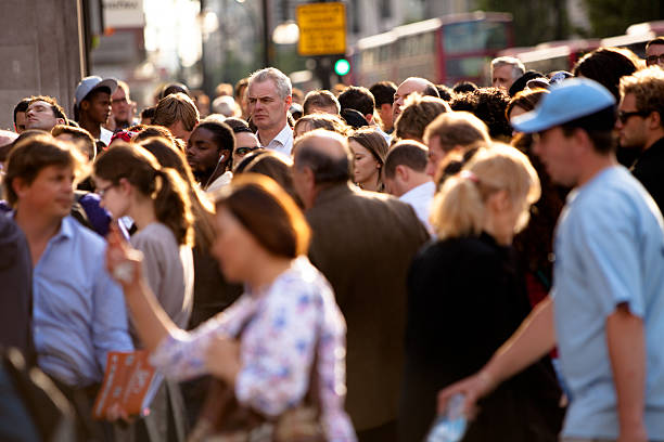 Tall man in a crowded intersection stock photo
