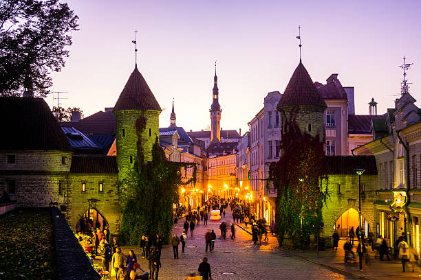 Tallin City Gates, Estonia Tallinn, Estonia City view including towers that form part of the historical city fortifications at the gateway to the historical district  with people at a market in the street estonia stock pictures, royalty-free photos & images