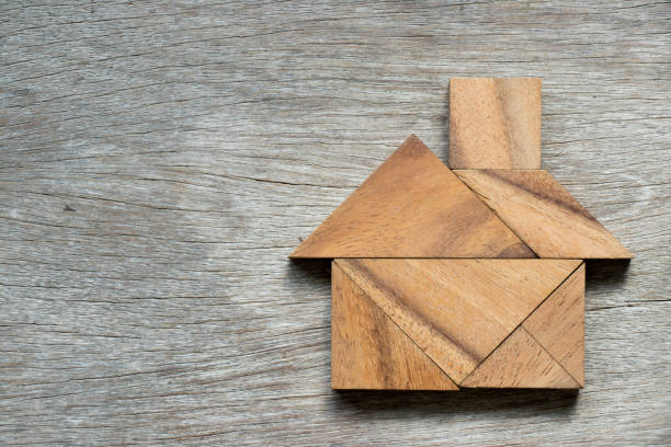 rompecabezas de tangram en forma casera sobre fondo de madera - tangram casa fotografías e imágenes de stock