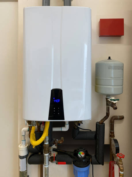 Tankless hot water heater mounted on wall of home stock photo