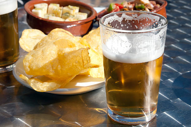 Tapas y cerveza, potato chips and fresh beer in Spain stock photo