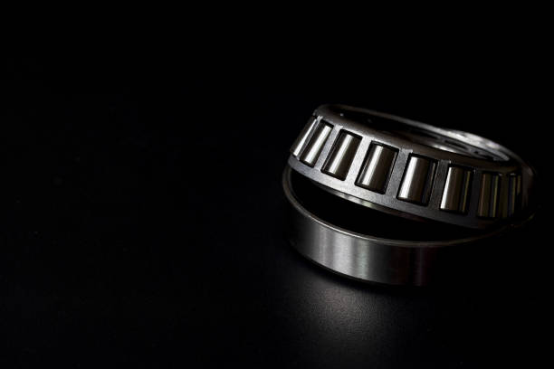 Tapered roller bearing on black background, Spare part of mechanical industry. stock photo