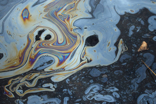 Tar water Iridescent colors abstract shapes on tar water surface of natural asphalt pit. pollution stock pictures, royalty-free photos & images