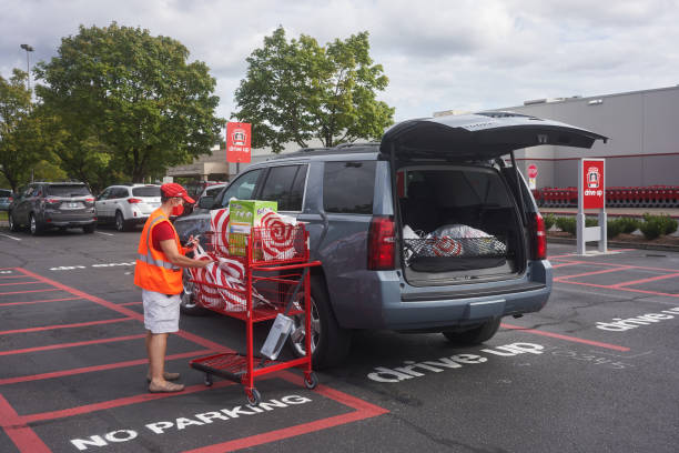 Target Store Drive-up Service Tigard, OR, USA - Sep 19, 2020: A Target store employee brings bagged items out to a customer's car parked in the drive-up area outside the Target Tigard store during the coronavirus pandemic. curbsidepickup stock pictures, royalty-free photos & images