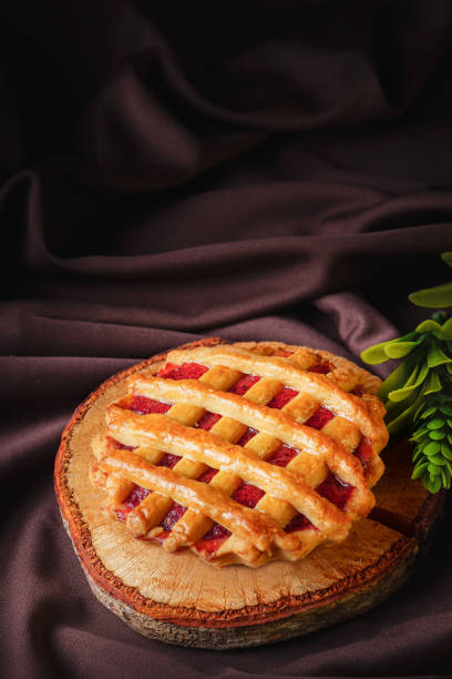 tartlet or tart filled with homemade delicious strawberry jam on a brown wood and cloth for a snack stock photo