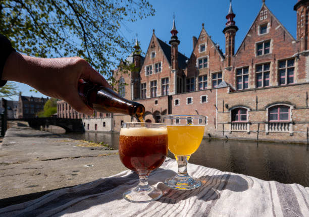 Tasting of Belgian beer on open cafe or bistro terrace with view on medieval houses and canals in Bruges, Belgium stock photo