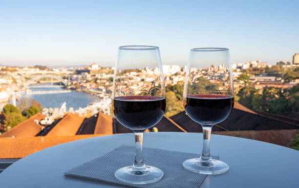 tasting of different fortified dessert ruby, tawny port wines in glasses with view on douro river, porto lodges of vila nova de gaia and city of porto, portugal - oporto imagens e fotografias de stock