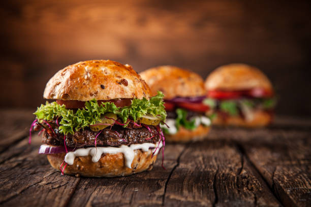 Tasty burgers on wooden table stock photo
