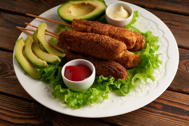 Tasty corn dog with sauce and salad served on white plate stock photo