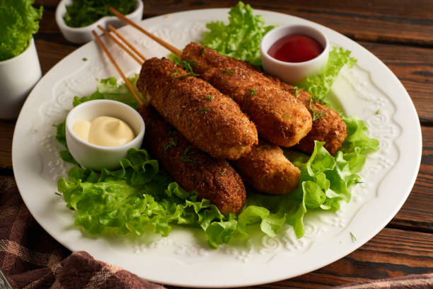 Tasty corn dog with sauce and salad served on white plate stock photo