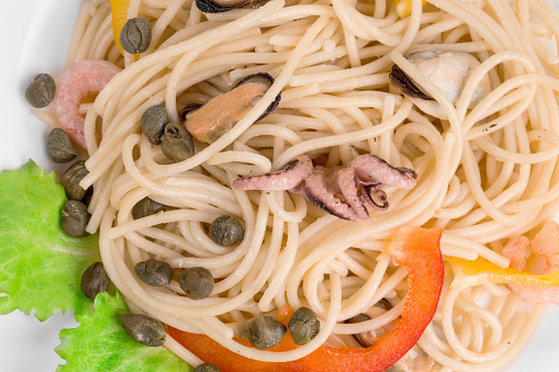 Tasty italian pasta with seafood. It occupies the entire surface of the image. Close-up.