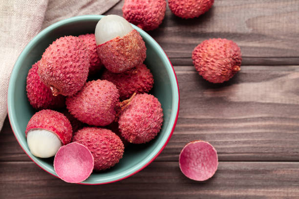 Tasty lychee in bowl on wooden table stock photo