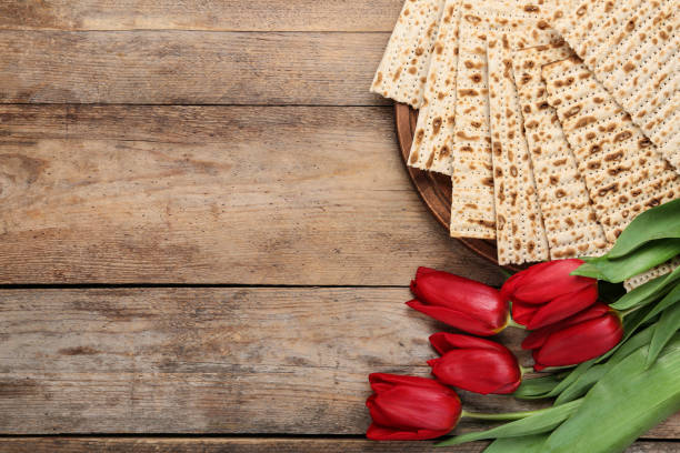 Tasty matzos and flowers on wooden table, flat lay with space for text. Passover (Pesach) Seder Tasty matzos and flowers on wooden table, flat lay with space for text. Passover (Pesach) Seder passover stock pictures, royalty-free photos & images