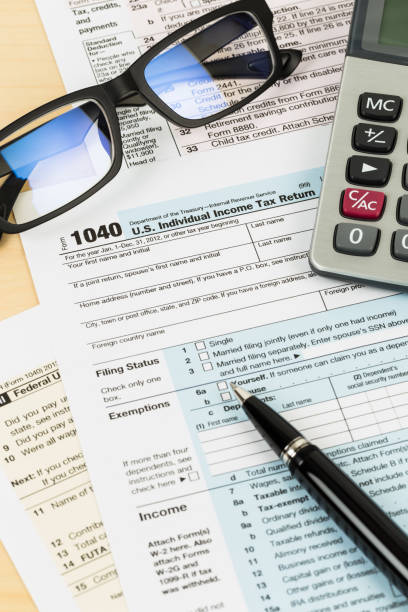 Tax form with glasses, calculator, and pen stock photo
