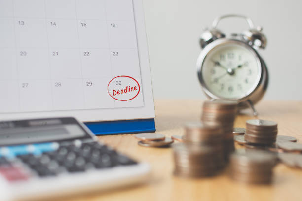 Tax payment season and finance debt collection deadline concept. Money coins stack, calendar, calculator and clock Tax payment season and finance debt collection deadline concept. Money coins stack, calendar, calculator and clock approaching stock pictures, royalty-free photos & images