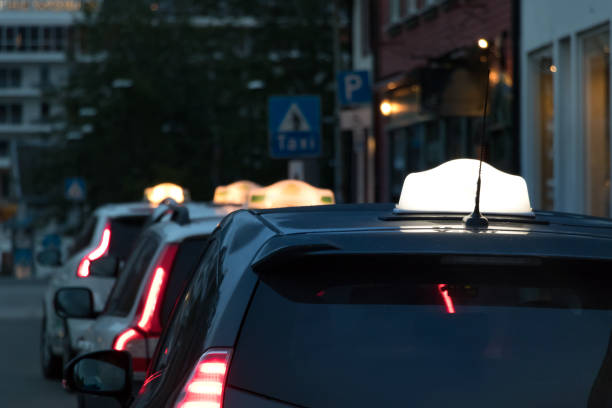 een taxi teken op het dak van een auto in het centrum van de stad tromsø, provincie akershus. - ramos stockfoto's en -beelden