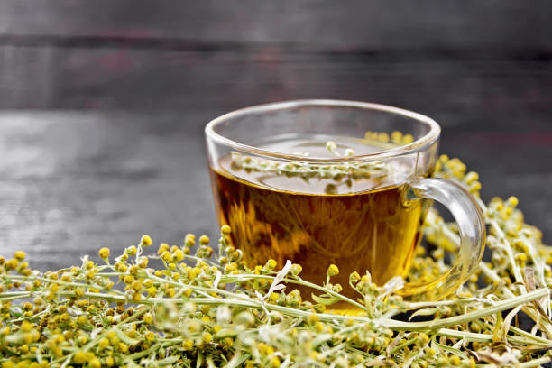 黑板上玻璃杯中的灰色蟲木茶 - tarragon tea 個照片及圖片檔
